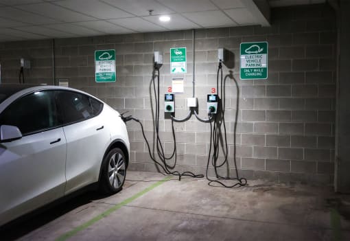a car plugged into a charging station in a parking garage