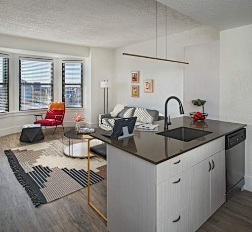 A modern kitchen with a black countertop and white cabinets.