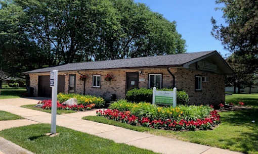 a small brick building with a sign in front of it