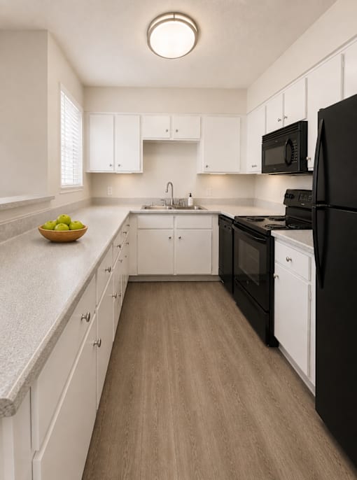 A kitchen with black appliances and white cabinets.