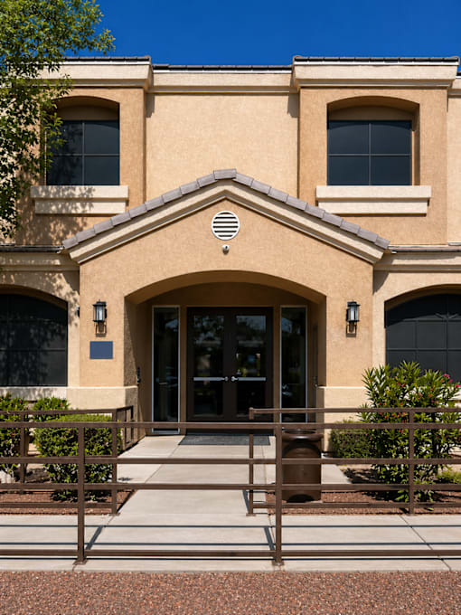 A building with a brown facade and a large arched entrance.