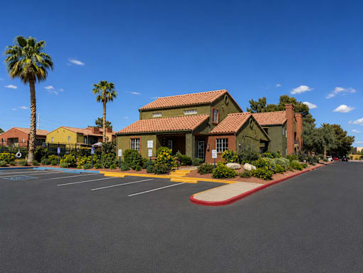 A building with a red roof and palm trees in front.