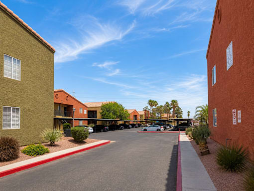 A parking lot is surrounded by two buildings.