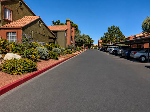 A street lined with houses and parked cars under a clear blue sky.