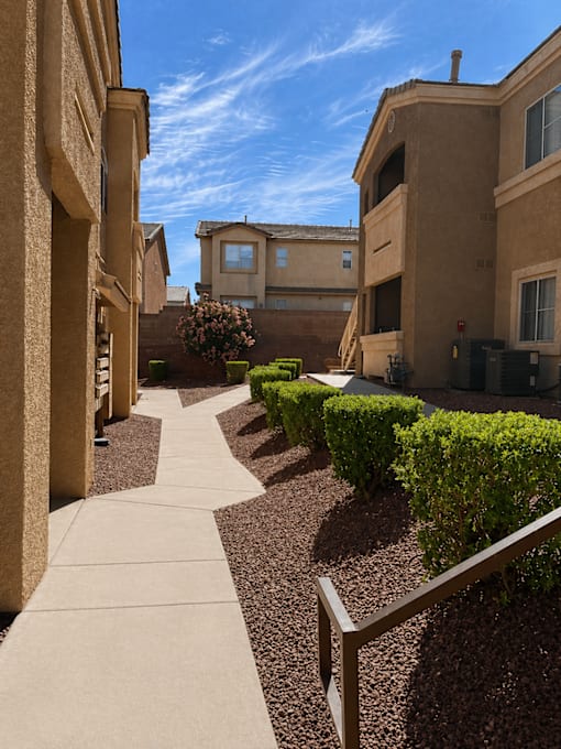 A row of houses with a sidewalk in front of them.
