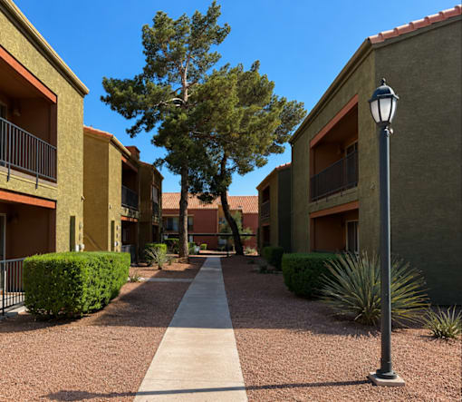 A street light stands on a sidewalk in front of a building.