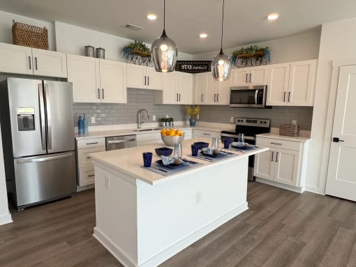 a large kitchen with white cabinets and stainless steel appliances