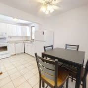 a kitchen with a table and chairs and a refrigerator
