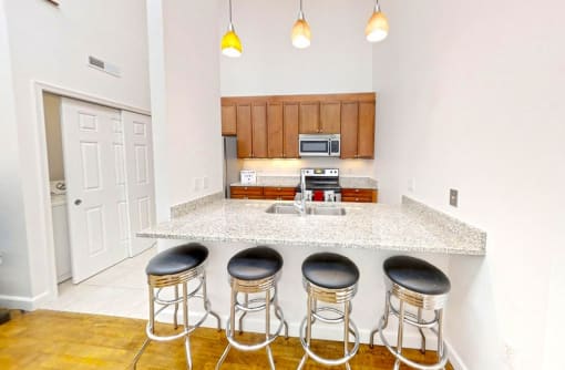 a kitchen with an island and four stools in front of it