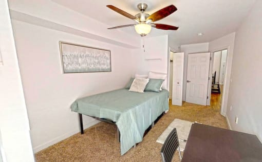 a bedroom with a bed and a ceiling fan