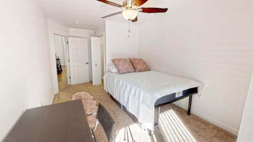 a bedroom with a bed and a ceiling fan