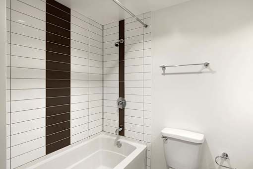A white toilet sits next to a white bathtub in a bathroom. at The View, Los Angeles, 90005