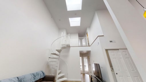 a home with a 16 foot ceiling and a spiral staircase