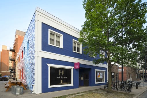 a blue and white building with a tree in front of it