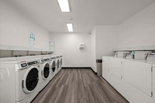 A laundromat with a row of washers and dryers.