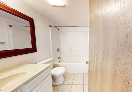 a bathroom with a white toilet next to a white bathtub
