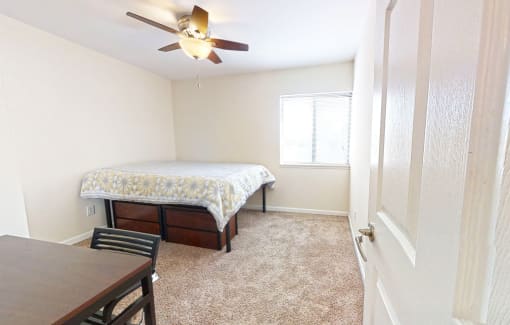a bedroom with a bed and a ceiling fan