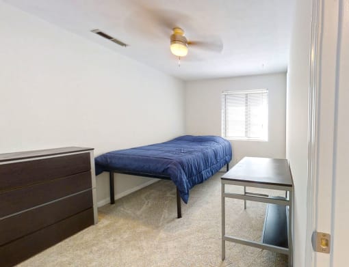 a bedroom with a bed and a desk