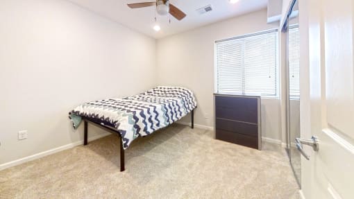 a bedroom with a bed and a ceiling fan