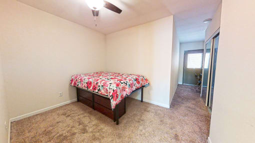 a bedroom with a bed and a ceiling fan