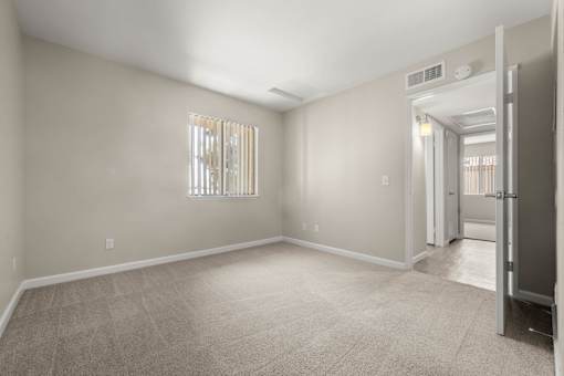 a empty room with a door to a hallway and a closet