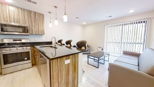 a kitchen with an island and a living room in the background