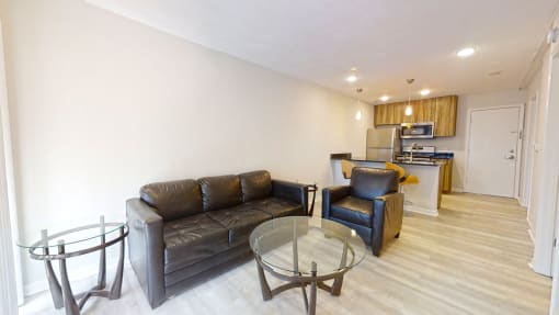 a living room with a couch a table and a kitchen in the background