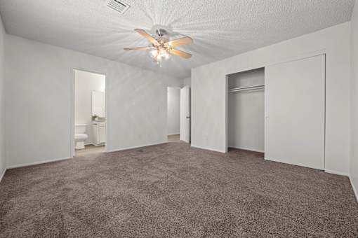 a living room with carpet and a ceiling fan