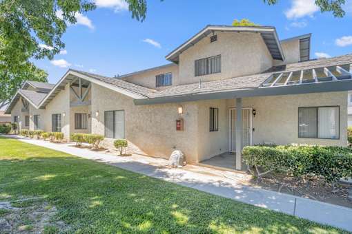 the front of a house with a sidewalk and grass