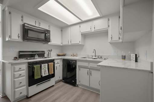 a kitchen with white cabinets and a stove and a microwave
