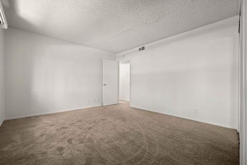 an empty living room with white walls and carpet