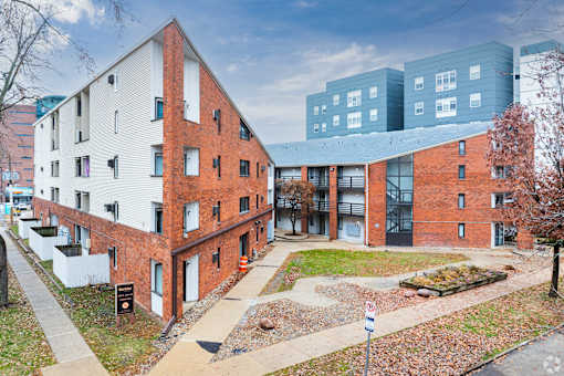 A red brick building with a white building in the background.