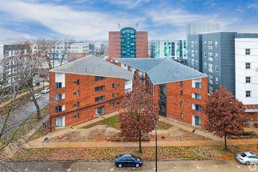 A red brick building with a black car parked in front.