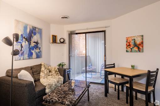 A living room with a couch, a table, and two chairs.
