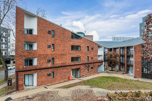 A red brick building with a tree in front of it.