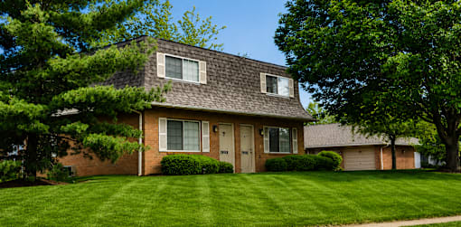 A house with a brown roof and a grey garage door.