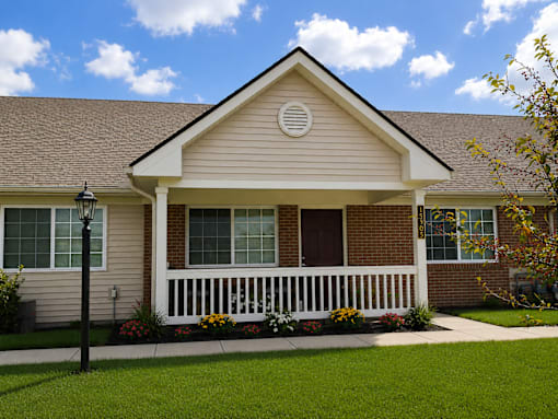 A house with a brown roof and a white porch.