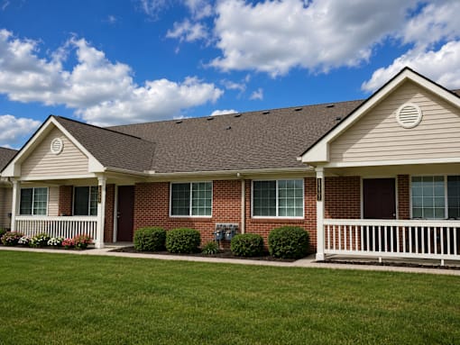A house with a brown roof and a white fence.