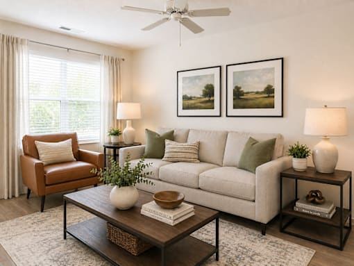 A living room with a brown leather chair, a white couch, and a coffee table with a plant on it.