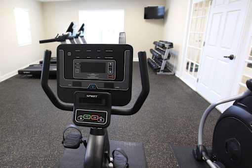 A black exercise bike with a digital screen in a room with a white door.