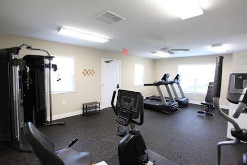 A gym with treadmills, elliptical machines, and other exercise equipment.
