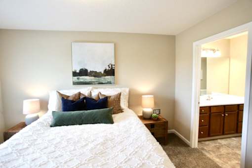 A bedroom with a large bed and a painting on the wall.
