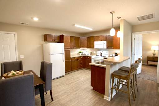 A kitchen with a white refrigerator and wooden cabinets.
