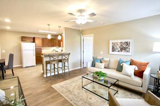 A living room with a couch, chairs, and a dining table.
