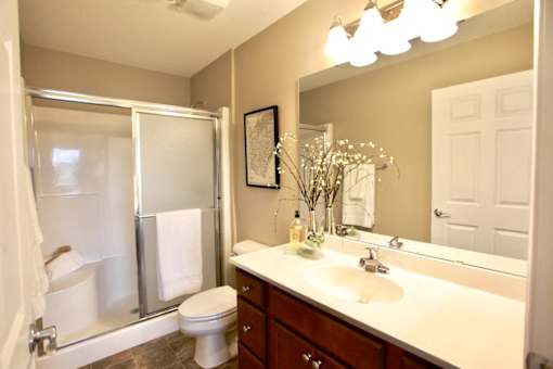 A bathroom with a toilet, sink, and shower.
