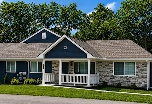 An apartment with a blue siding and a white porch.