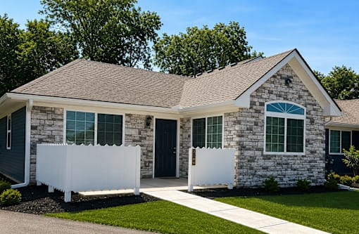 An apartment with a white fence in front.