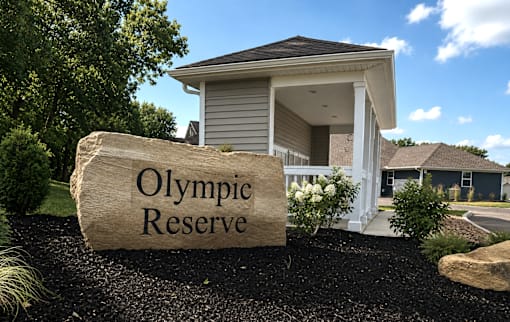 A large stone with the words Olympic Reserve is in front of a mailbox area.