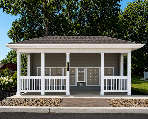 A mailbox area with roof and white railing.