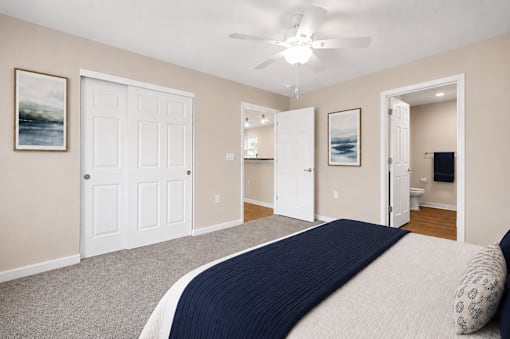 A bedroom with a large bed and a ceiling fan.